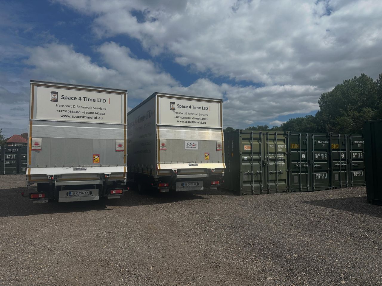 Rear view of branded removal trucks next to storage containers