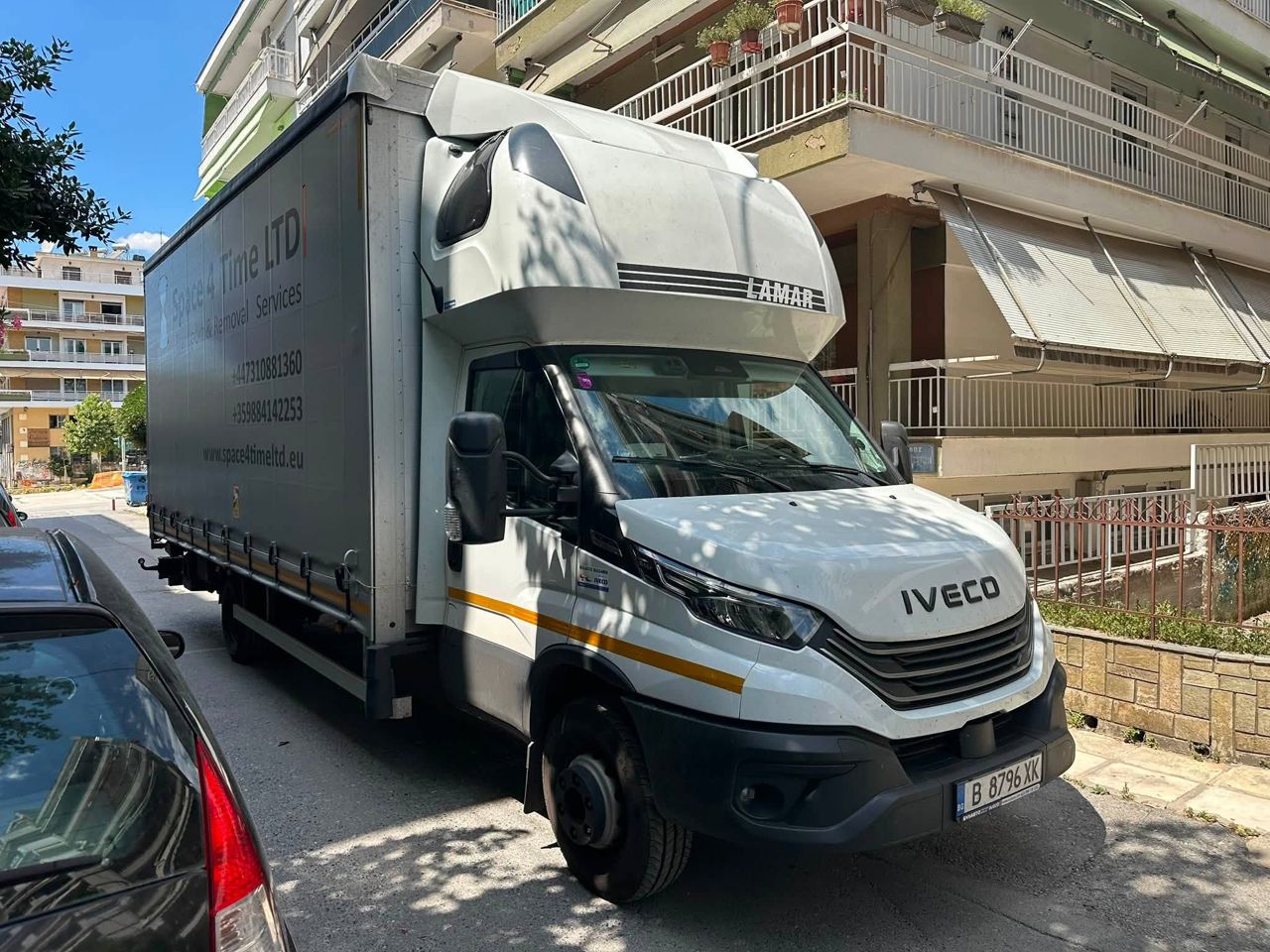 Movers loading wrapped furniture and boxes onto the lift